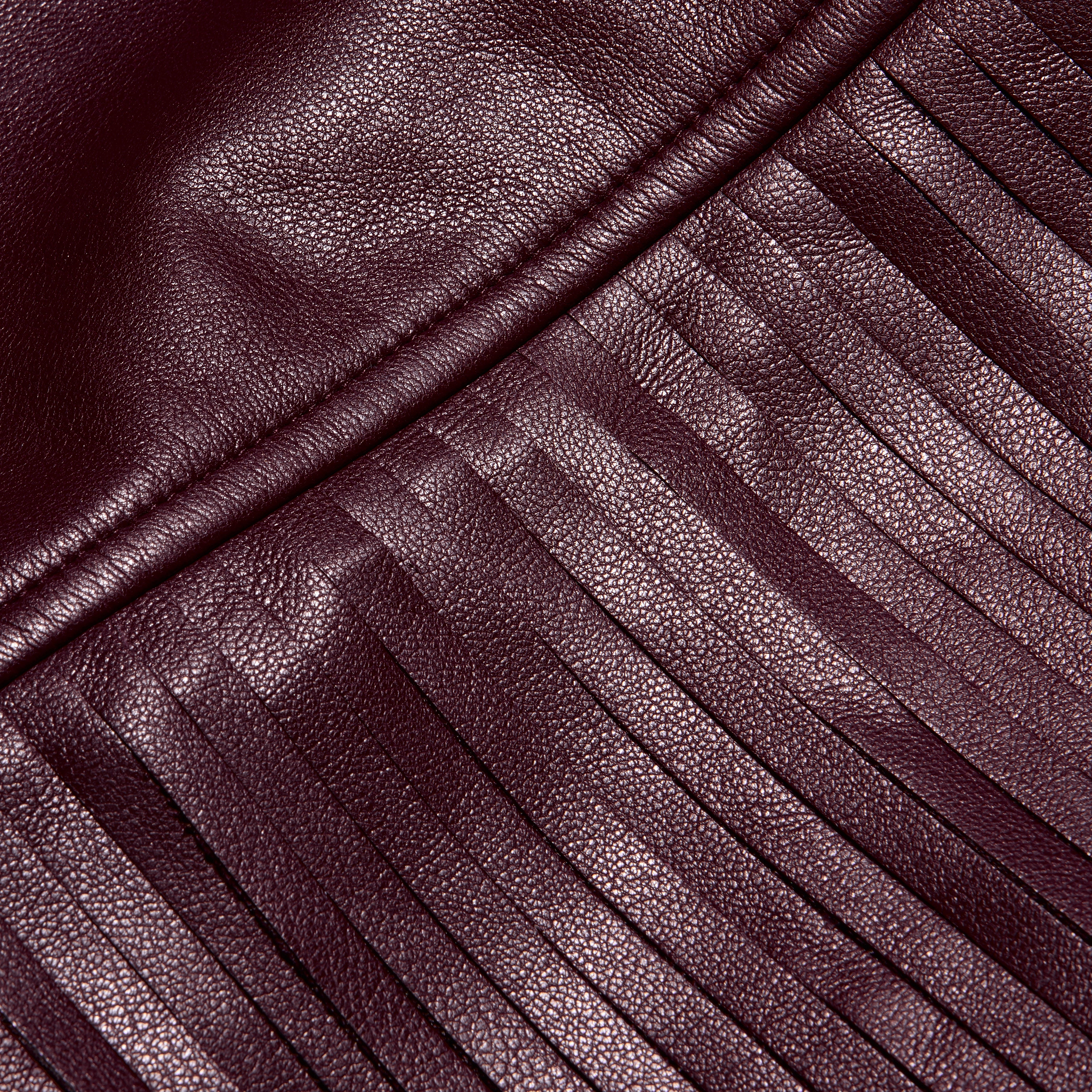 Karoline Fringe Skirt in deep burgundy vegan leather featuring a seam with long, vertical fringe.