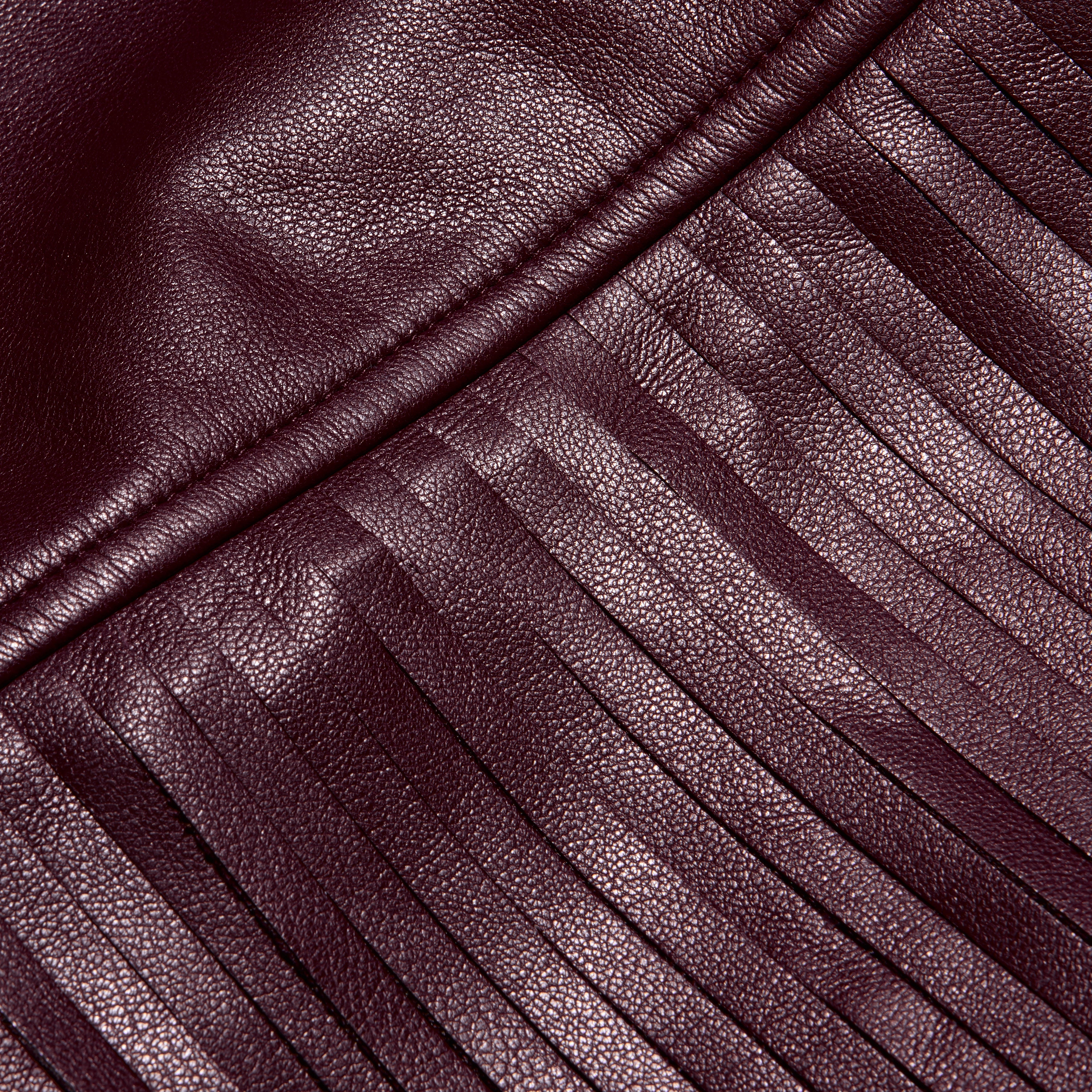 Karoline Fringe Skirt in deep burgundy vegan leather featuring a seam with long, vertical fringe.
