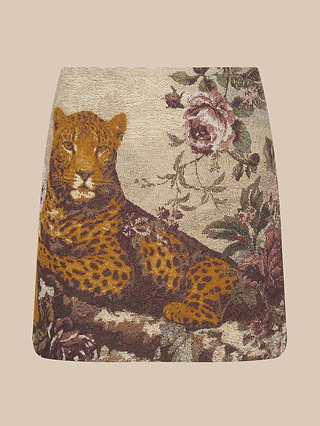 The Marseille Mini Skirt is a vintage-inspired mini skirt crafted from luxurious Italian jacquard, featuring a reclining leopard surrounded by pink and burgundy flowers on a beige background.