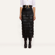 Sevigne Fringe Skirt in black, featuring layered fringe and worn with a double-buckle belt and tall boots.