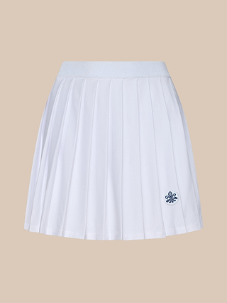 The Aryna Pleated Tennis Skirt is a white pleated design featuring an elastic waistband and a small navy blue embroidered fleur-de-lis logo near the hem. Crafted from performance fabric with built-in shorts for comfort and ease, it is displayed on a plain beige background.