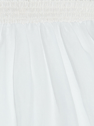 Close-up of white fabric with a ruched, gathered elastic waistband at the top and soft pleats flowing downward, creating a textured, airy appearance—perfect for the breathable Evangelina Maxi Skirt.
