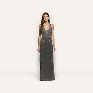 A woman wears a hand-beaded L’AGENCE sleeveless, deep-V neck top and matching Zeta Beaded Maxi Skirt, both covered in silver beading.
