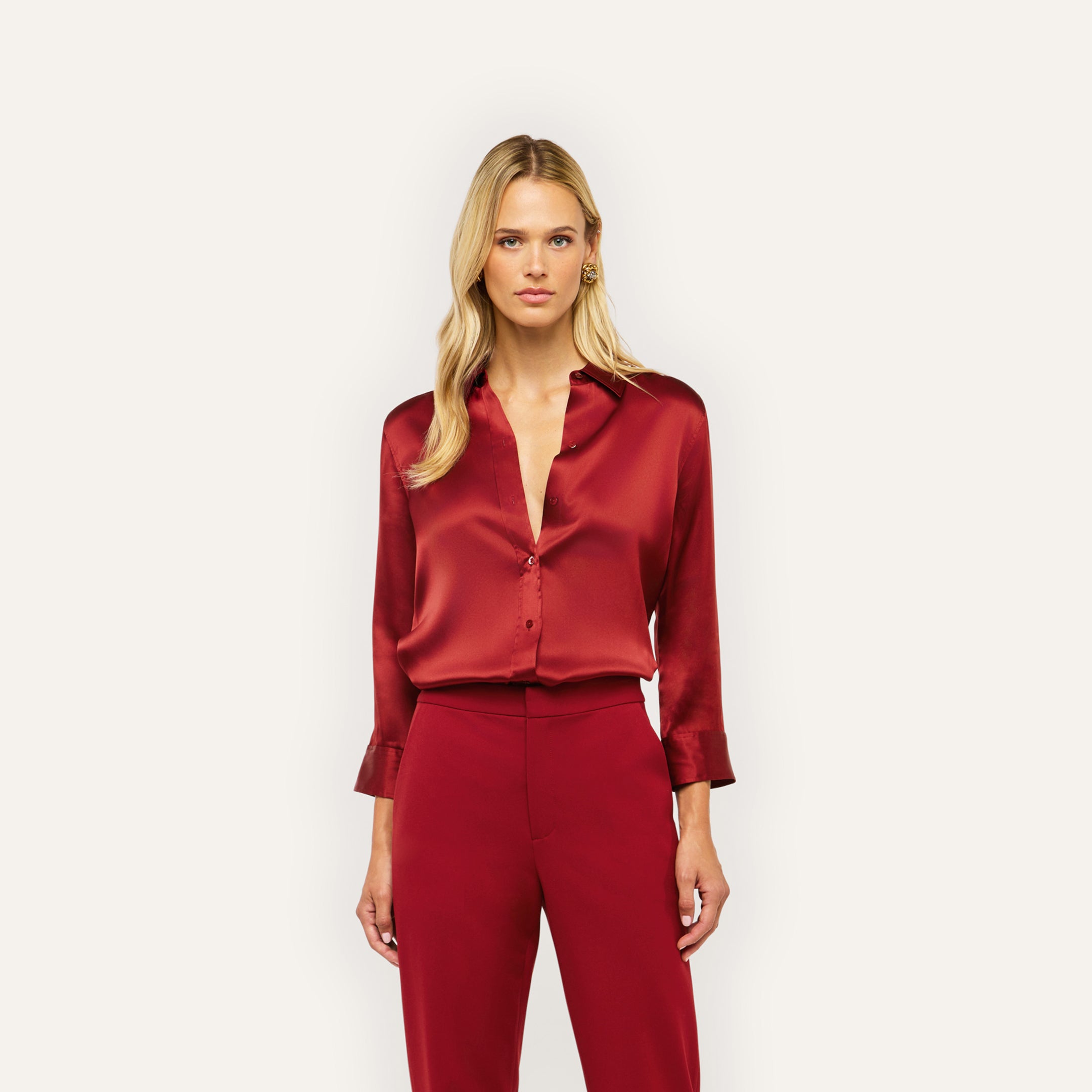 A woman wears a burgundy Dani Silk Blouse tucked into matching silk charmeuse trousers.