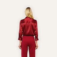 Back view of a person wearing a long-sleeved red silk charmeuse Dani Silk Blouse and matching trousers.