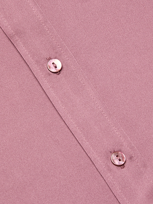 Close-up of the Dani Silk Blouse in dusty pink, featuring two round, shiny buttons at the seam. The smooth, lustrous 100% silk fabric gives this button-down a timeless and elegant look.