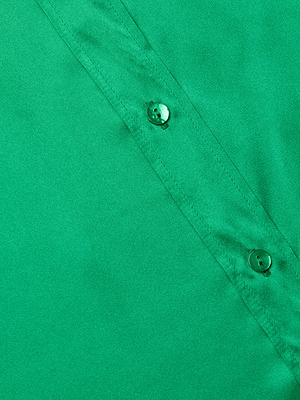 Close-up of the Dani Silk Blouse in green, showcasing its elegant design with a diagonal button placket and two visible green buttons. Features 3/4 sleeves for a stylish, refined look.