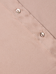 Close-up of the Dani Silk Blouse in light brown, featuring a diagonal stitched seam and two round, shiny buttons along the seam. The smooth texture of the silk material is visible.