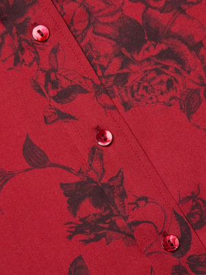 Close-up of the Dani Silk Blouse by L'AGENCE, a burgundy silk shirt with a subtle black floral print and shiny red buttons in a diagonal row, adding elegance to this button-down.