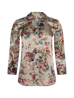 The Dani Silk Blouse features long sleeves, a classic collar, and a relaxed fit. Its button-down design showcases a floral tapestry print in red, green, blue, and brown on a light beige silk background.