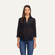 A woman with long brown hair wears the Dani Cotton-Silk Blouse—a black button-down top with 3/4 sleeves—paired with blue jeans, standing against a plain, light background.