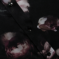 Close-up of the Dani Silk Blouse in silk charmeuse, styled in a dark hue with shiny black buttons and a floral pattern of pink and white roses.