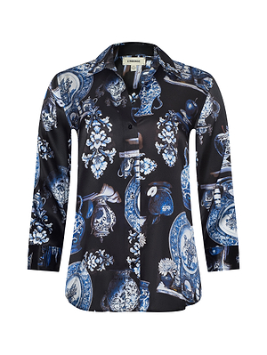 The Dani Silk Blouse by L'AGENCE is a button-down top with a dark base, showcasing an intricate blue and white porcelain dishware and floral print.