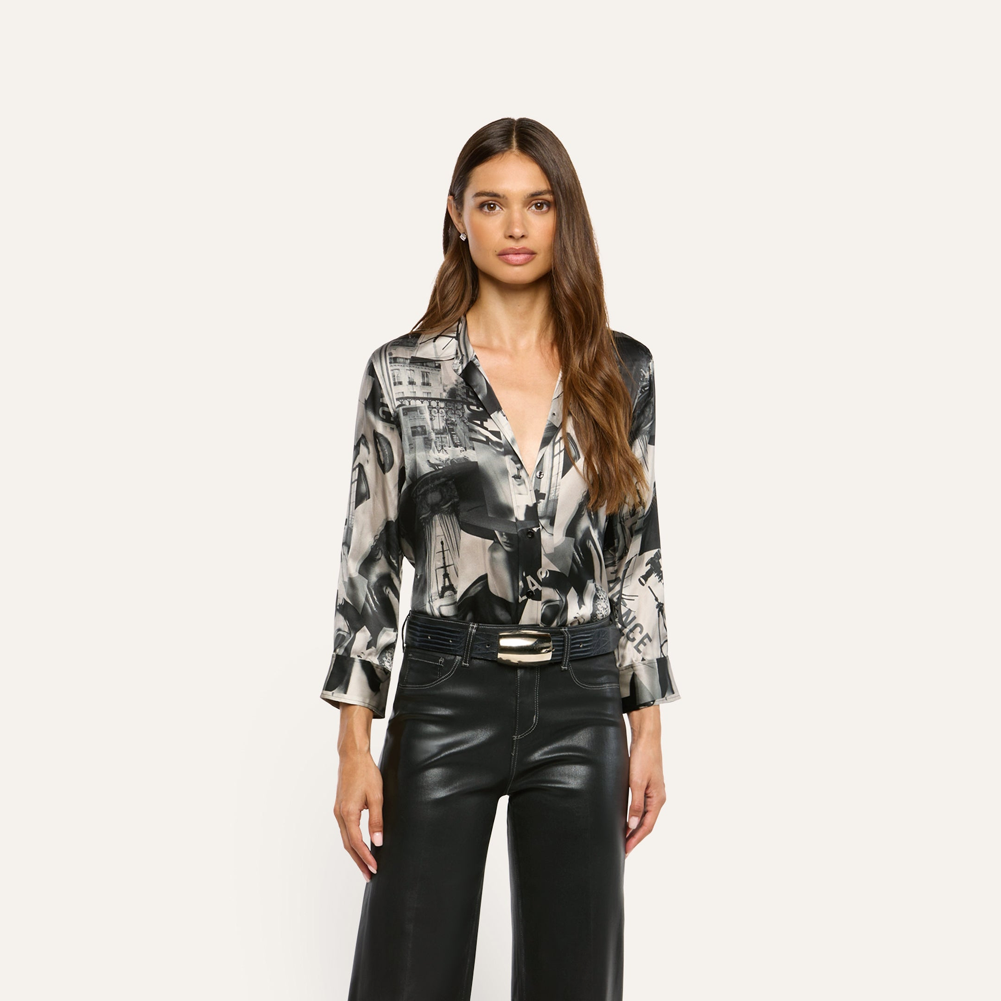 A long-sleeved Dani Silk Blouse in a black and white collage print, tucked into black trousers with a dark belt.
