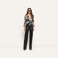 A woman wearing sunglasses, a black and white graphic print Dani Silk Blouse, and black trousers.