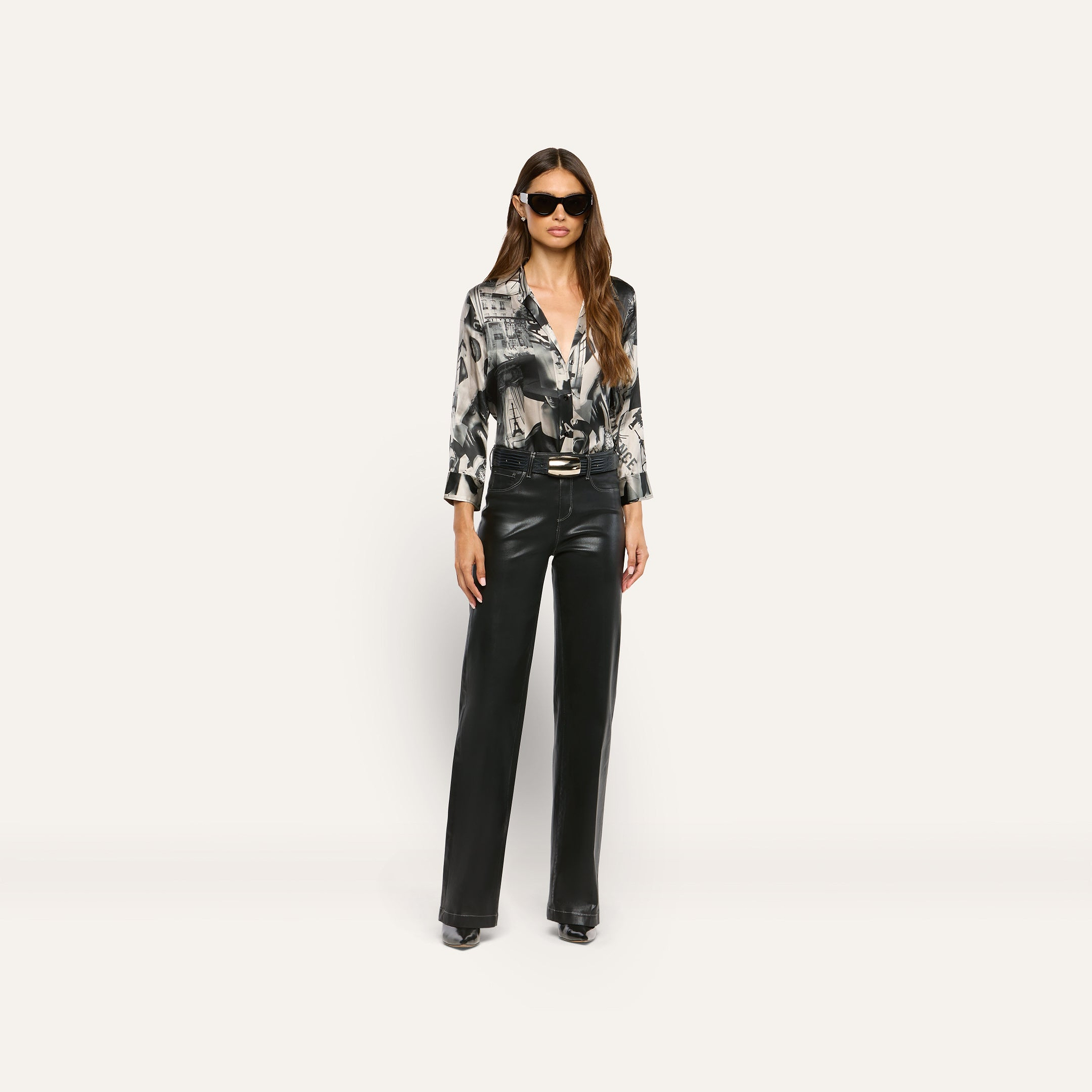 A woman wearing sunglasses, a black and white graphic print Dani Silk Blouse, and black trousers.