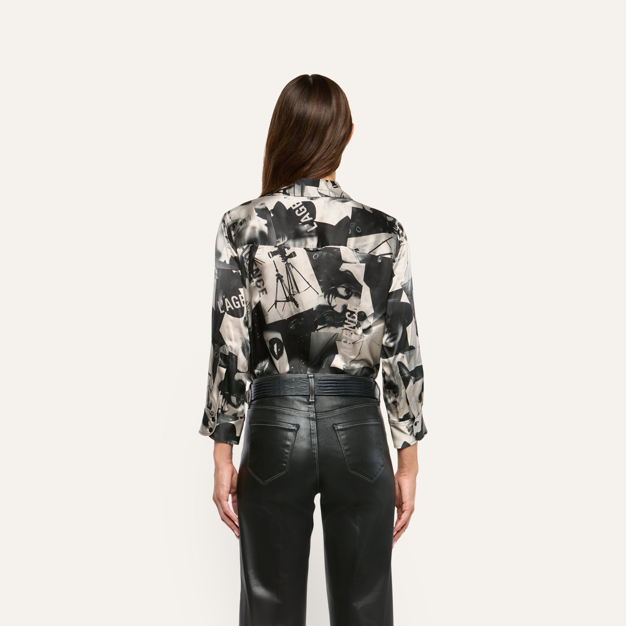 Back view of the Dani Silk Blouse in a black-and-white collage print, tucked into black pants.