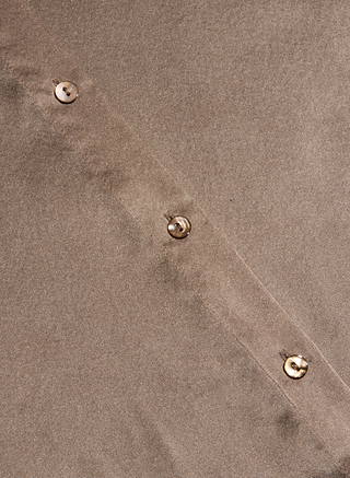 Close-up of the Tyler Silk Blouse in cardamom brown, showcasing its smooth, slightly textured silk fabric and diagonal button-down placket with three round, light-colored buttons.