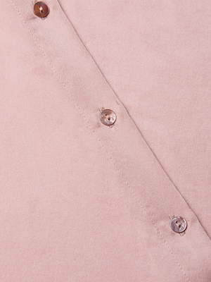 Close-up of the Tyler Silk Blouse in light pink, featuring three shiny round buttons arranged diagonally, showcasing its smooth silk texture and precise stitching along the edge.