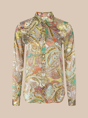 The Tyler Silk Blouse by LAGENCE is a long-sleeve button-down featuring a colorful paisley print in yellow, orange, green, and brown on neutral beige silk.