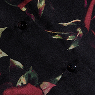 Close-up of the Tyler Silk Blouse fabric, showcasing a dark floral pattern with red and green leaves reminiscent of a rose print, accented by two black buttons. The material appears soft and slightly textured, making it a refined addition to your business wardrobe.