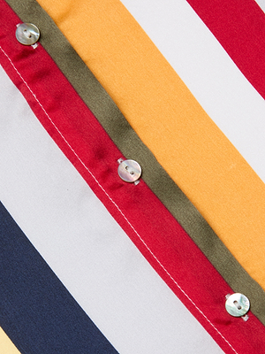 Close-up of the L'AGENCE Tyler Silk Blouse features a fabric with multi-colored vertical stripes—red, yellow, olive green, navy blue, and white—and a row of small shiny buttons sewn along the red stripe.