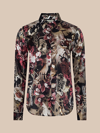The Tyler Silk Blouse is a long-sleeve, button-down shirt crafted from silk, featuring a statement abstract floral and jewelry print in rich red, brown, black, and beige tones. It is displayed on a plain beige background.