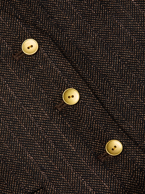 Close-up of the Drina Pinstriped Vest by L'AGENCE, a tailored women's vest in brown pinstriped fabric with diagonal gold buttons along the front.