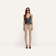 A woman wears a dark grey silk Lexi Silk Camisole, beige skinny jeans with a black belt, and black pointed-toe heels.
