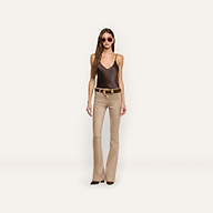 A person wearing a brown silk Lexi Silk Camisole, a brown belt with a decorative gold buckle, and tan flared pants.
