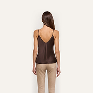 Back view of a person wearing a Lexi Silk Camisole with thin straps and beige trousers.