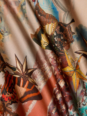 Close-up of the Lexi Satin Camisole with a travel postcard print featuring orange, yellow, and brown butterflies, seashells, and starfish on a soft, flowing satin fabric.