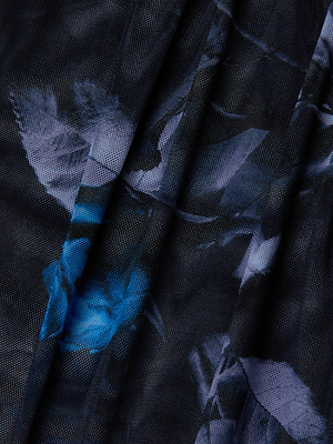 Close-up of sheer, dark fabric with blue and purple floral patterns and pleated folds, highlighting the textured, semi-transparent surface of the Trista Bodysuit.