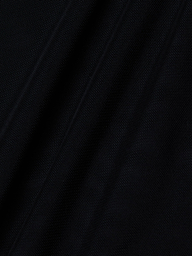 Close-up of the Trista Bodysuit’s black mesh fabric, showcasing its visible weave texture and diagonal folds that create subtle shadows and highlights across the surface.
