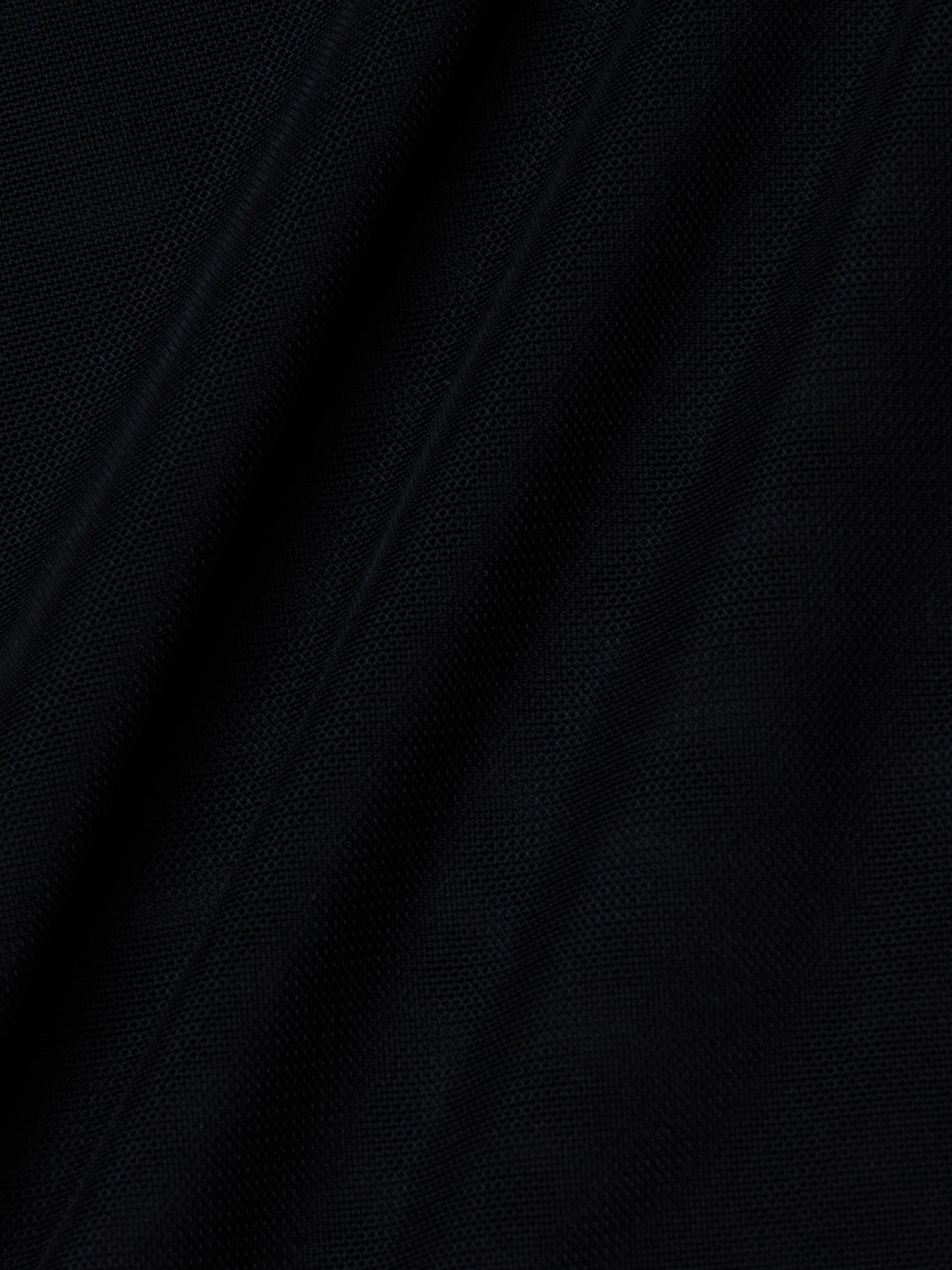 Close-up of the Trista Bodysuit’s black mesh fabric, showcasing its visible weave texture and diagonal folds that create subtle shadows and highlights across the surface.