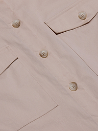 Close-up of the Pearson Poplin Shirt in light beige, featuring large buttons and two angled flap pockets, with a focus on the utility-inspired design, fabric texture, and detailed stitching.