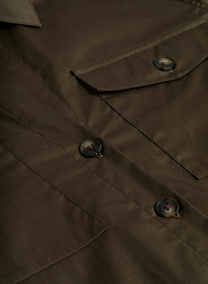 Close-up of the L'AGENCE Sale Pearson Blouse, a utility-inspired button-up shirt in brown or olive green, highlighting the chest pocket, three buttons, and stitching details on stretch cotton sateen fabric.