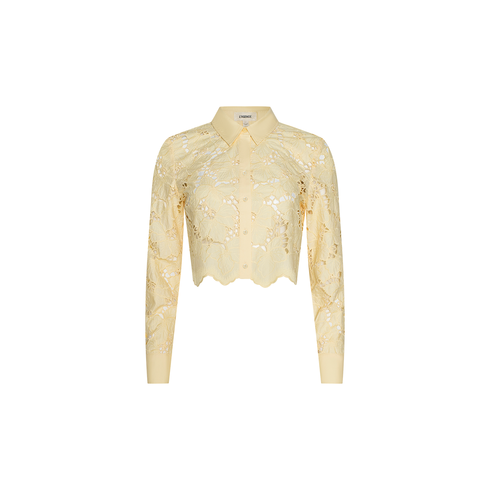 The Seychelle Cropped Eyelet Blouse is a light yellow, long-sleeve sheer poplin lace blouse featuring a collared neckline, cropped cut, and scalloped hem, displayed on a plain white background.