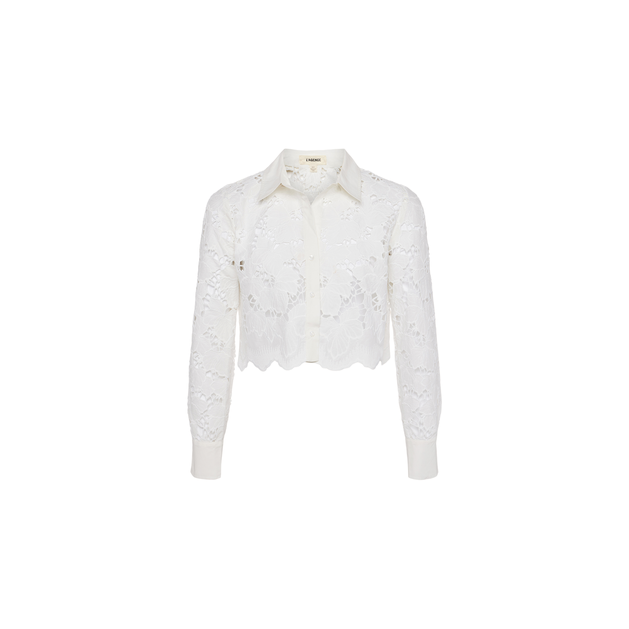 Seychelle Cropped Eyelet Blouse—white long-sleeve cropped blouse featuring visible floral eyelet lace patterns, a scalloped hem, button-down front, and classic collar. Displayed on a plain white background.