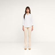A woman stands facing forward against a plain white background, wearing the Daniella Cotton-Blend Blouse with white stretch poplin three-quarter sleeves, beige pants, and tan shoes.