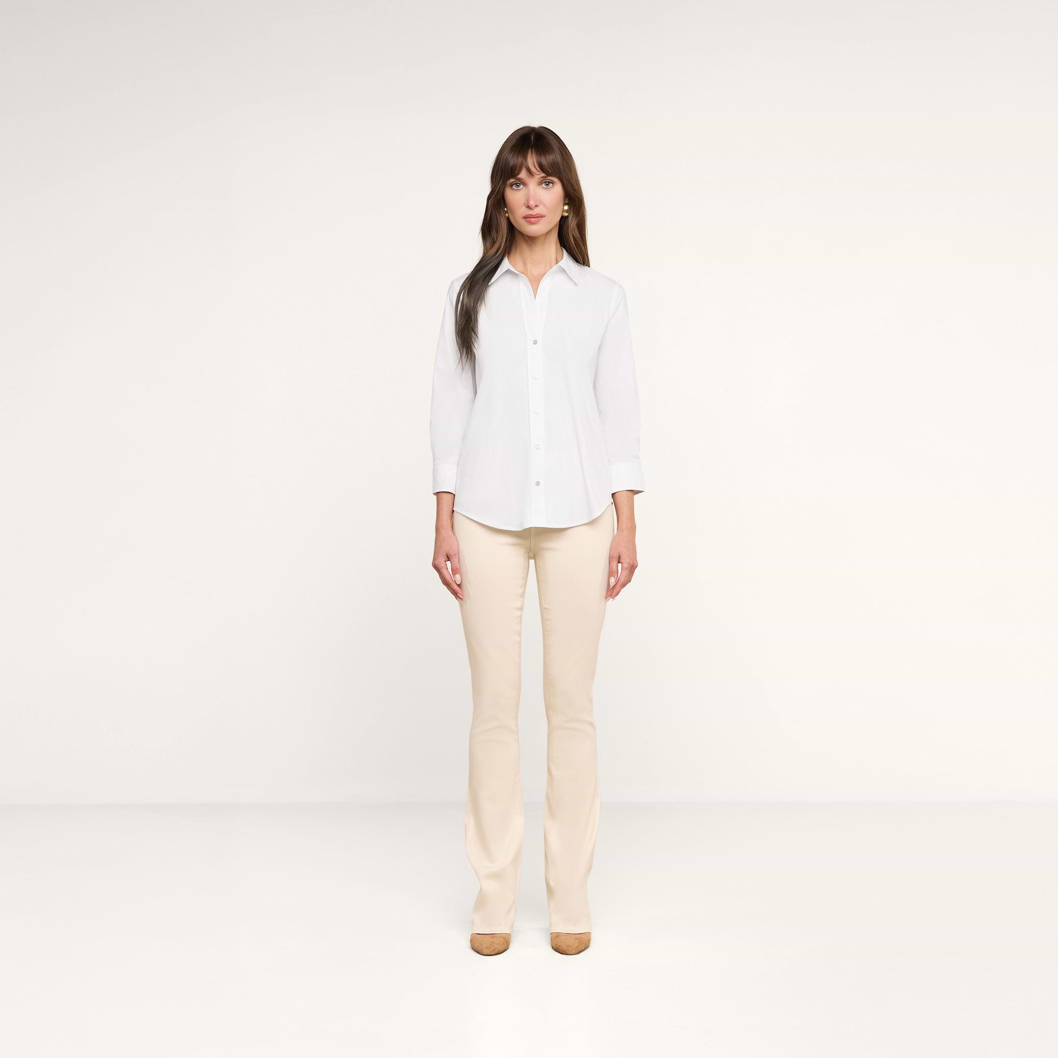 A woman stands facing forward against a plain white background, wearing the Daniella Cotton-Blend Blouse with white stretch poplin three-quarter sleeves, beige pants, and tan shoes.