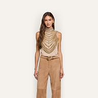 The Yun Crystal Tank is a sleeveless beige top featuring an elaborate high-neck collar and a draped bodice adorned with multiple layers of gold chains, perfect for holiday party wear.