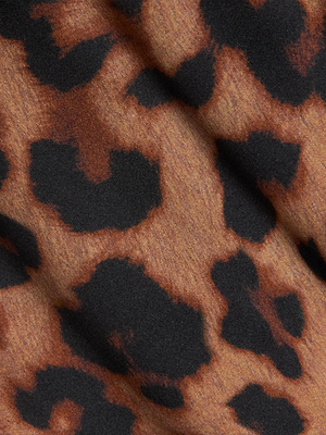 Close-up of the Calista Silk Camisole by L'AGENCE, showing its leopard print with irregular dark spots on a light brown, subtly textured silk fabric.