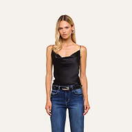 A woman with long blonde hair wears the Calista Silk Camisole in black and blue jeans, standing against a plain light background.