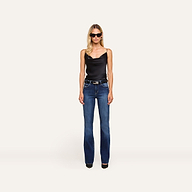 A woman in sunglasses, the Calista Silk Camisole, blue jeans, and black heels stands facing forward against a plain light background.