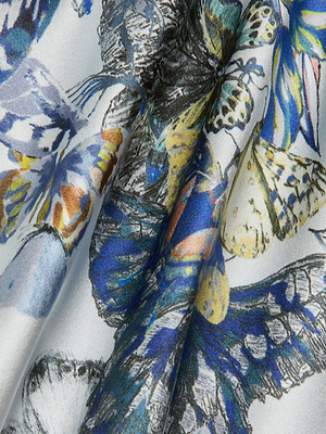 Close-up of the Calista Silk Camisole with a vibrant butterfly print in blue, yellow, orange, and black on white silk. The smooth fabric features detailed patterns, ideal for a stylish cropped camisole look.