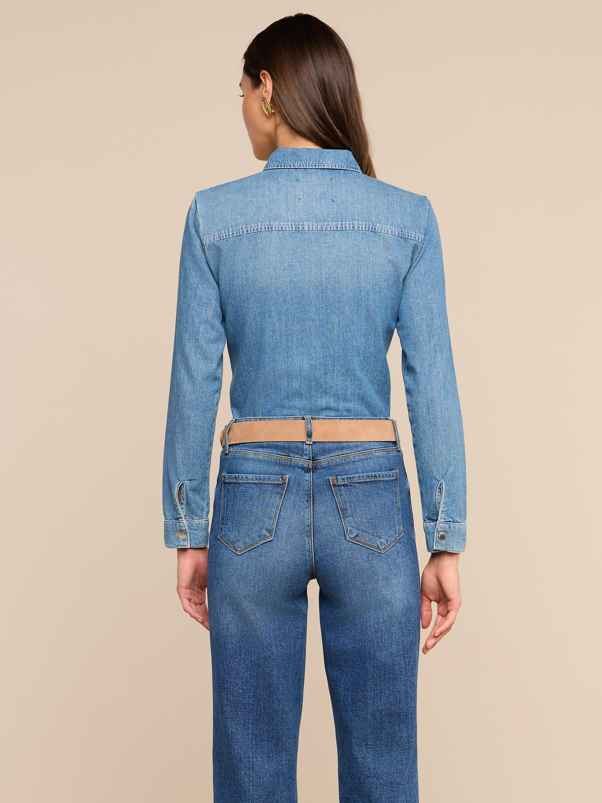 A person with long brown hair is shown from the back against a plain white background, wearing the Isla Shirt and medium wash jeans.