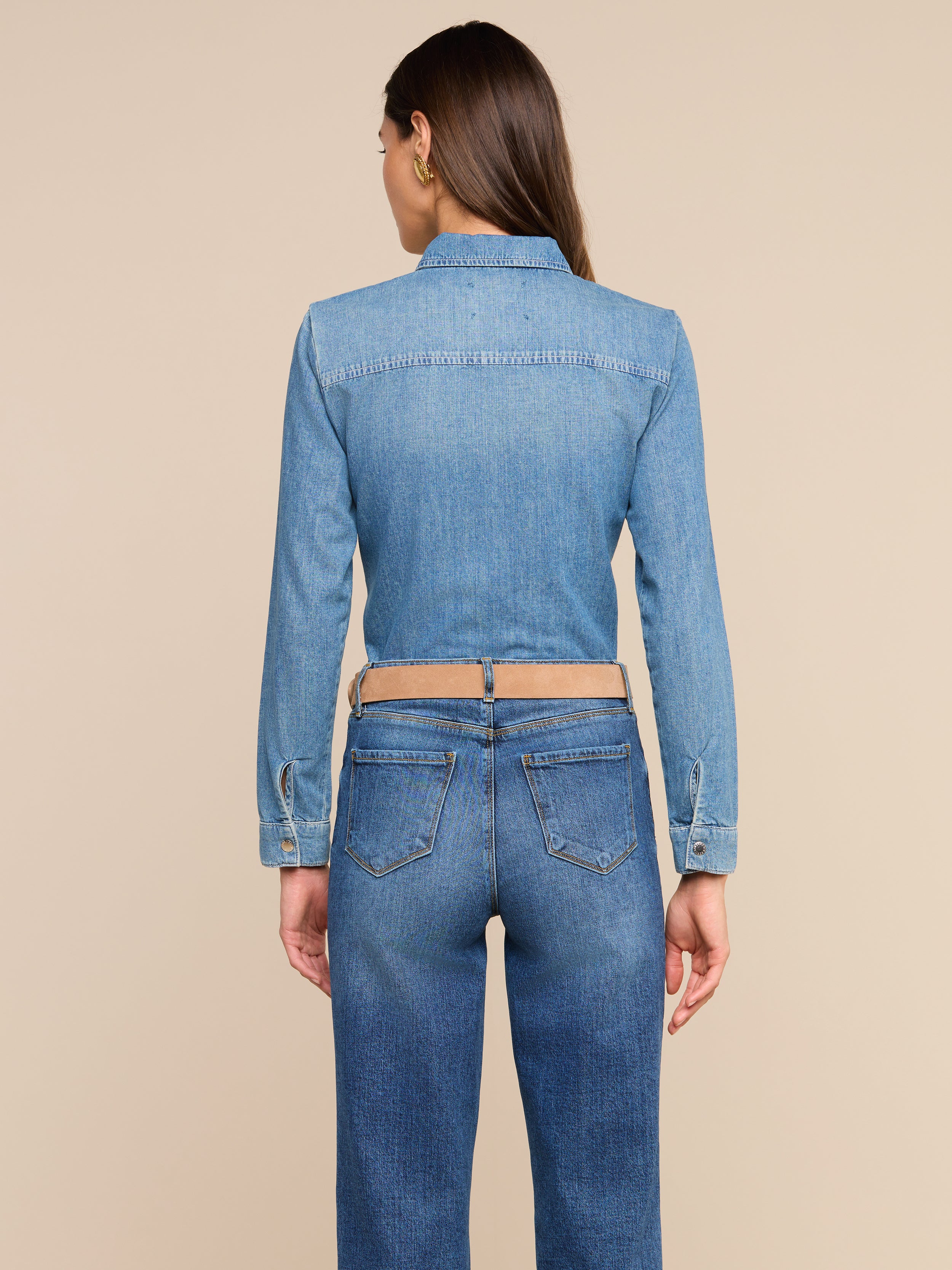 A person with long brown hair is shown from the back against a plain white background, wearing the Isla Shirt and medium wash jeans.
