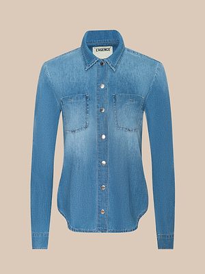 The Isla Shirt is a lightweight, long-sleeve blue denim top with a vintage wash, two chest pockets, silver front buttons, and a pointed collar, shown against a plain beige background.