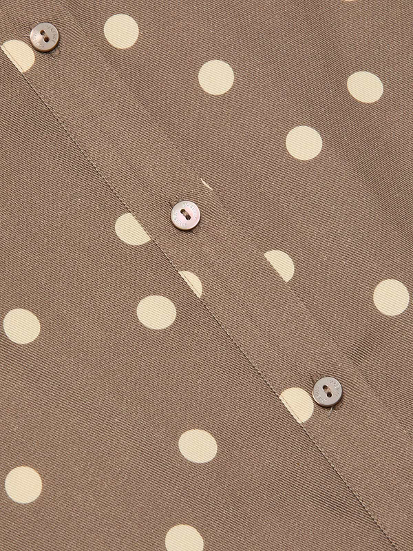 Close-up of the Ellery Button-Down Shirt in cardamom brown fabric with cream polka dots, featuring three light brown buttons sewn along a seam.